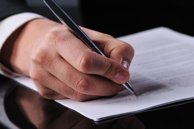 persona firmando un documento oficial