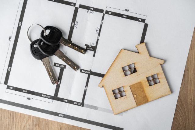 plano de una casa junto a las llaves de entrada